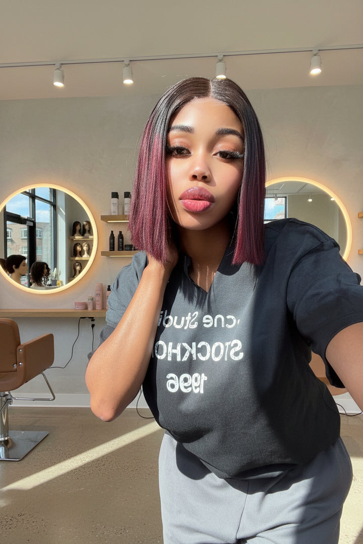 Person wearing a black t-shirt with white text, posing indoors.